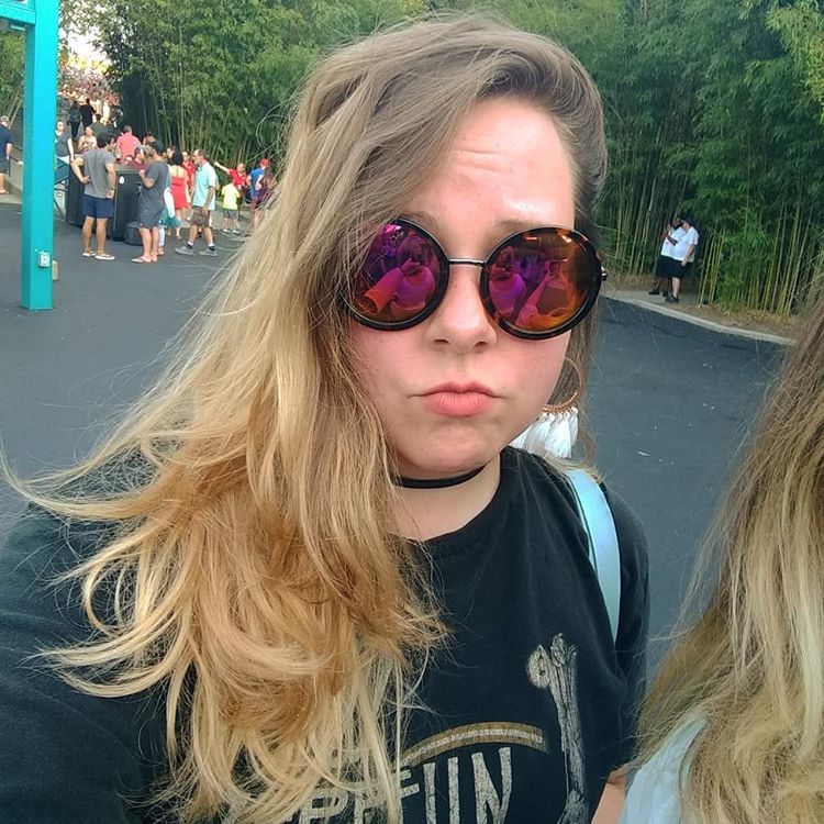 Blonde girl in Led Zeppelin band tee and big bohemian sunglasses at a Train band concert